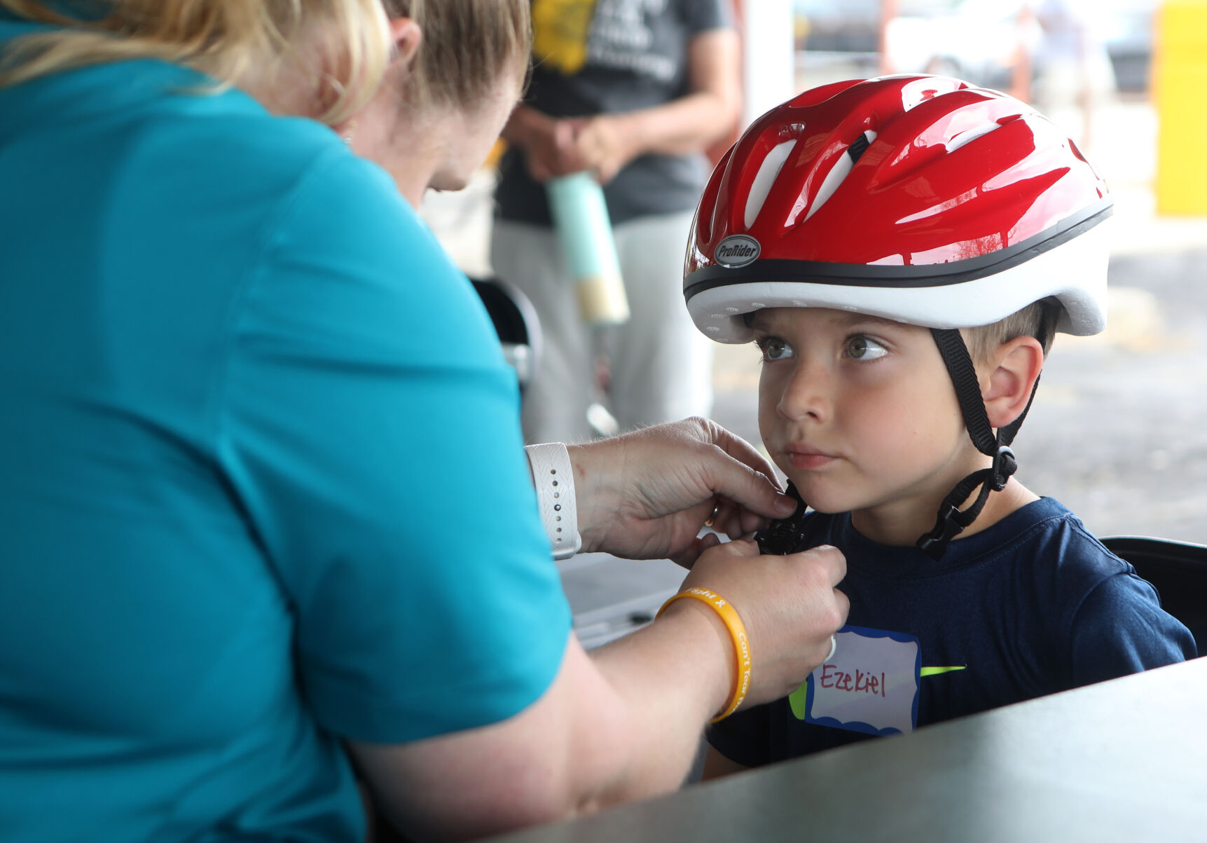 Heather Pratt fits Ezekiel Risley with a helmet